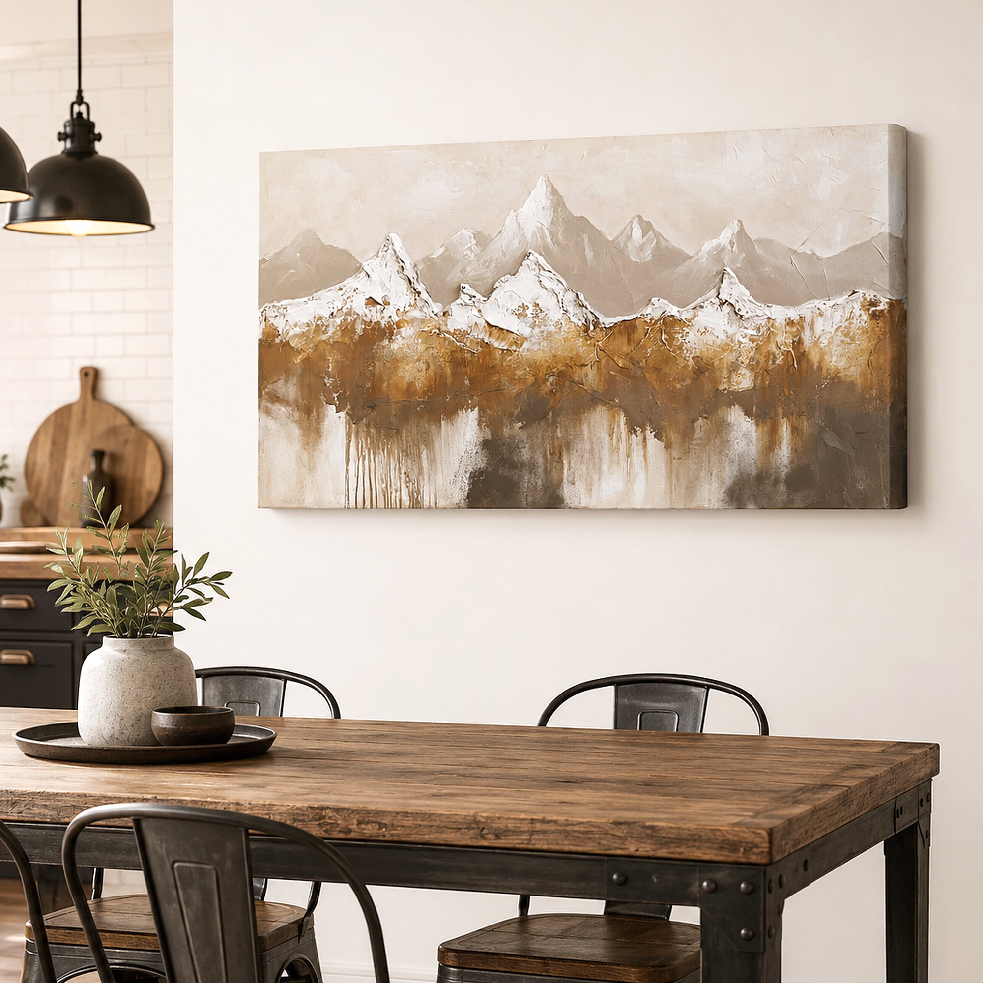 A rectangular canvas wall art print depicting snowy mountain peaks reflected in still water, styled in a warm dining room above a wooden table with chairs.