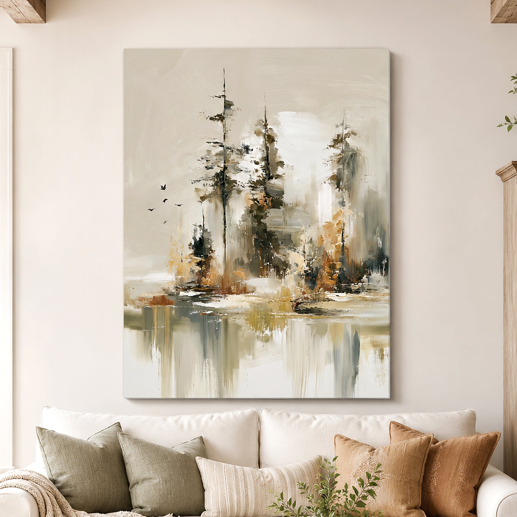 Abstract canvas wall art featuring stylized trees and water reflections in beige, gray, white, and muted gold tones, displayed above a white sofa with neutral throw pillows in a living room setting.